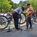Two kids repairing a bike tire