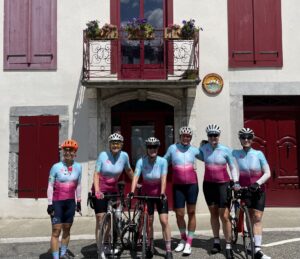 Six women in pink and blue bike jerseys in France for Le Tour de France Femmes