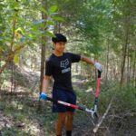 Boy cutting down overgrowth on Liberty Gulch Trail