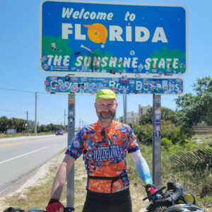 James Bogin in front of Welcome to Florida sign 