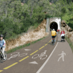 Rendering of proposed Alto Tunnel multiuse path with people biking and walking through tunnel entrance.