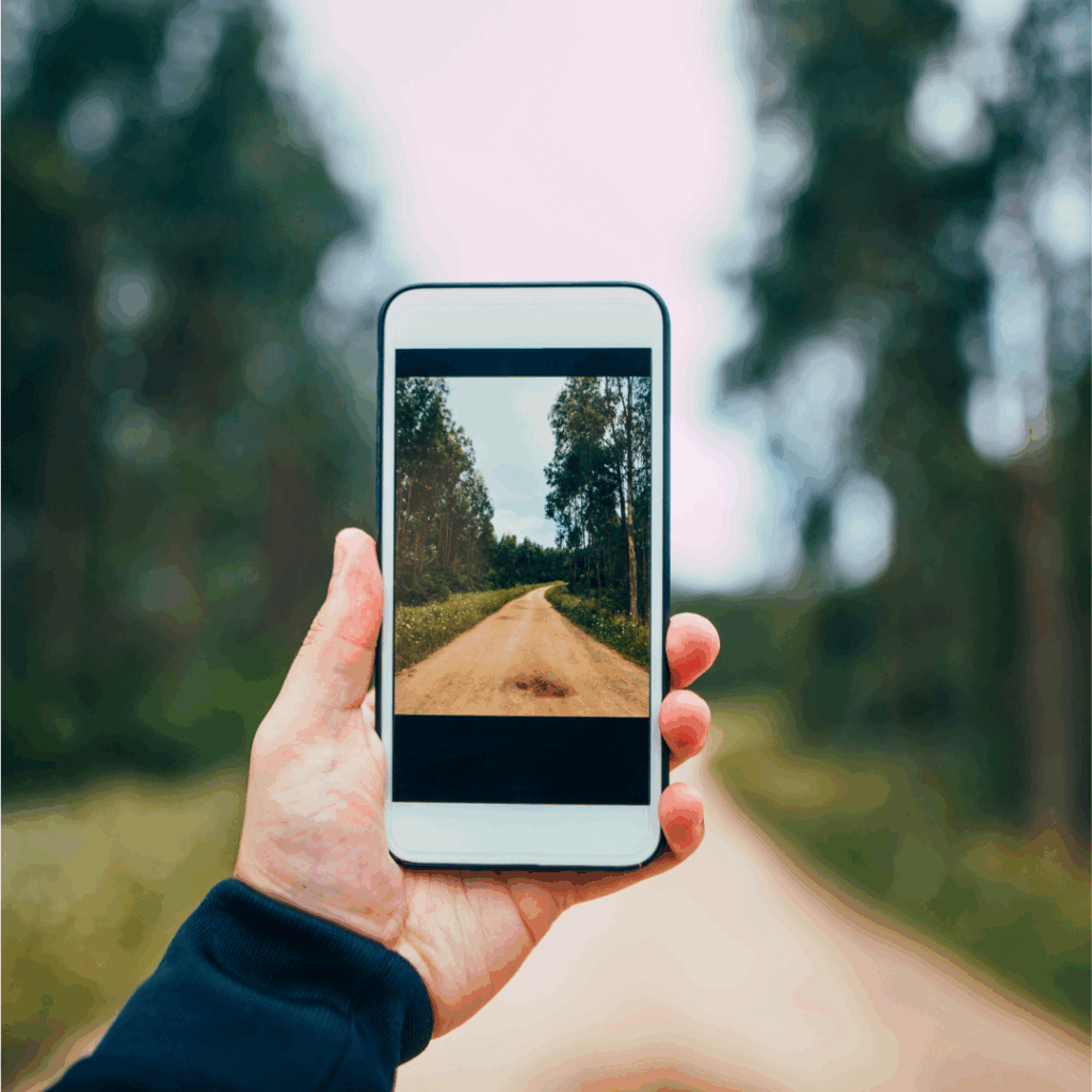 phone in hand taking a photo of a trail