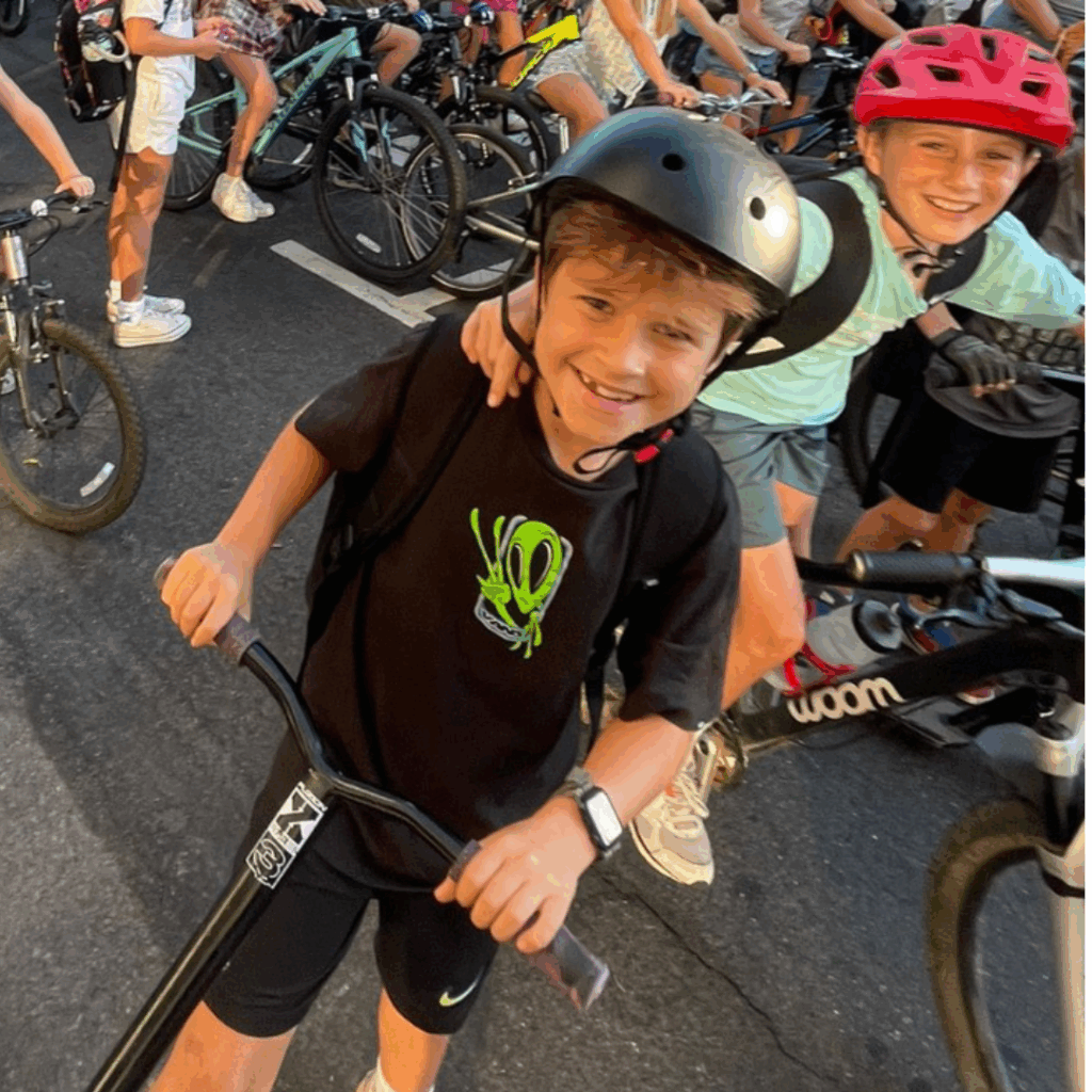 Boys with a scooter and a bike wearing helmets at a Walk and Roll to School event